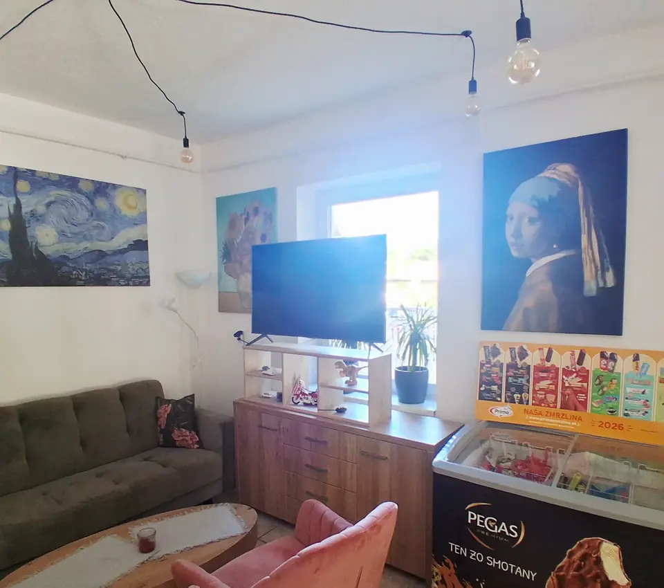 Útulný kútik s pohovkou, ružovými kreslami a televíznou obrazovkou